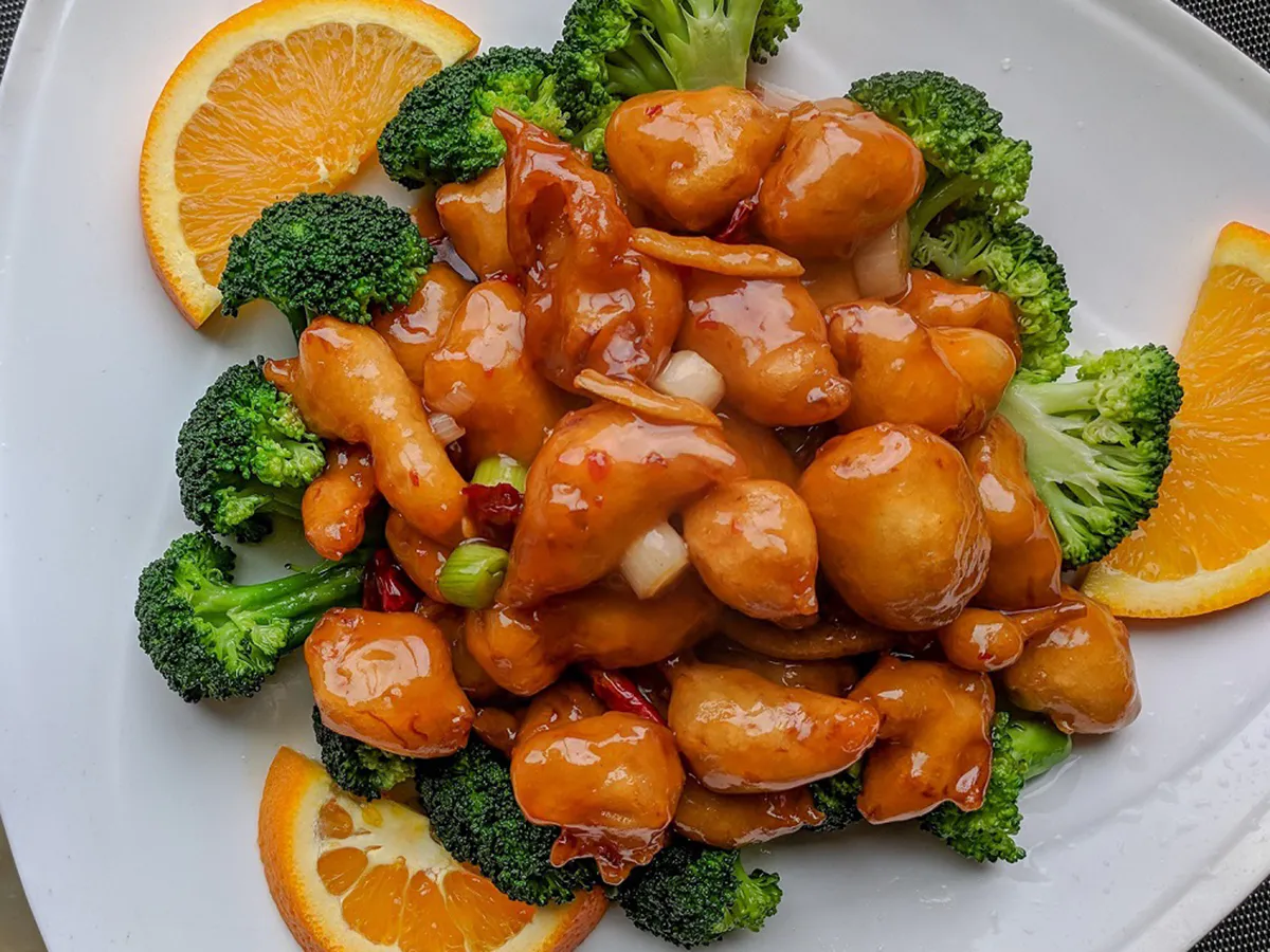 Sweet orange glazed chicken with fresh broccoli and orange slices